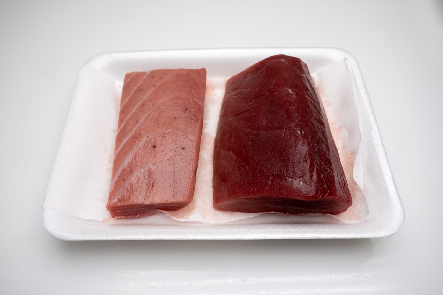 ถาดเนื้อชูโทโร่และอากามิจากซองระดับ 2 บนแผ่นซับสีขาว